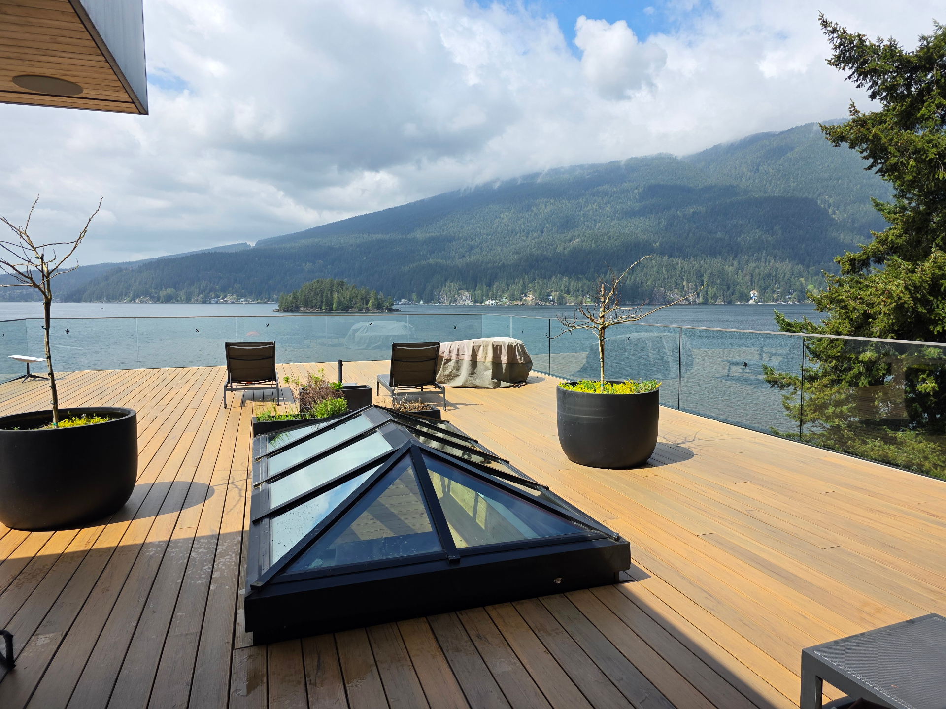 Crystal-clear glass skylight and railings on a waterfront deck overlooking the inlet after a Complete Window Cleaning visit